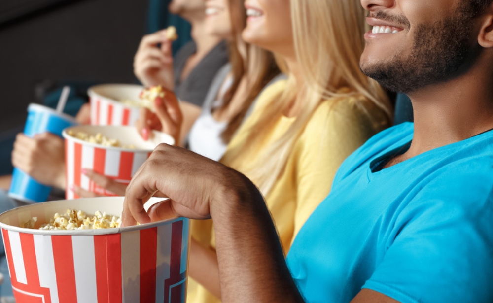 People eating popcorn while watching a film