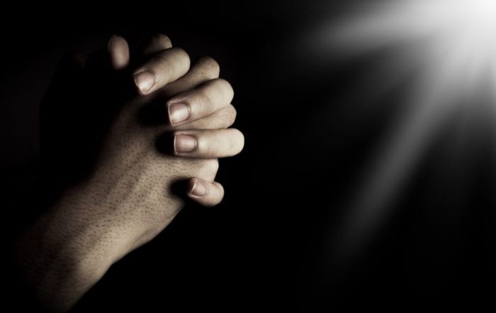 Praying hands with dark background